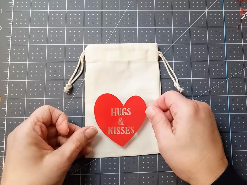 placing valentine vinyl on muslin bag