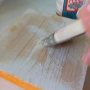 Applying modpodge to wood block before applying printable